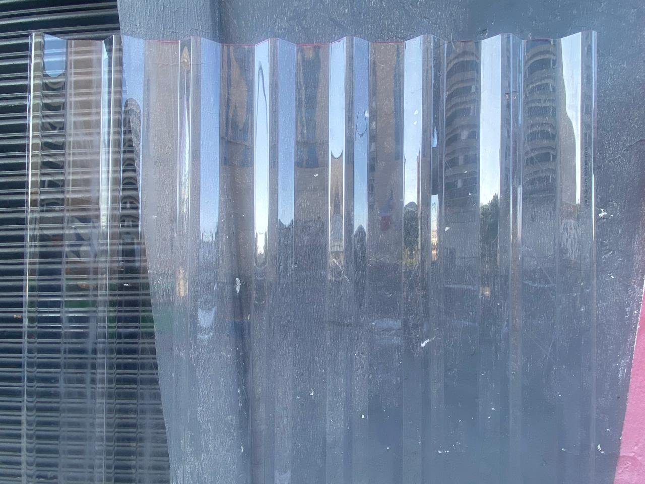 Lámina de policarbonato transparente, con fondo gris.